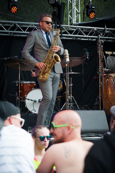 Saksofonisti Timo Lassy soittaa ja paidaton mies nauttii. Kuva: Tuomas Vitikainen