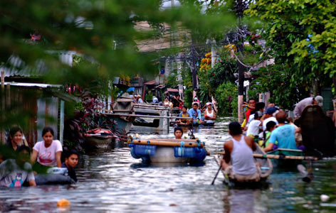 Ihmiset Filippiineillä liikkuivat veneillä hirmumyrskyn aiheuttamien tulvien vuoksi. Kuva: Veejay Villafranca.